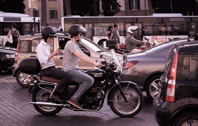 Dvaja ľudia sedia na motorke, čakajú v zápche